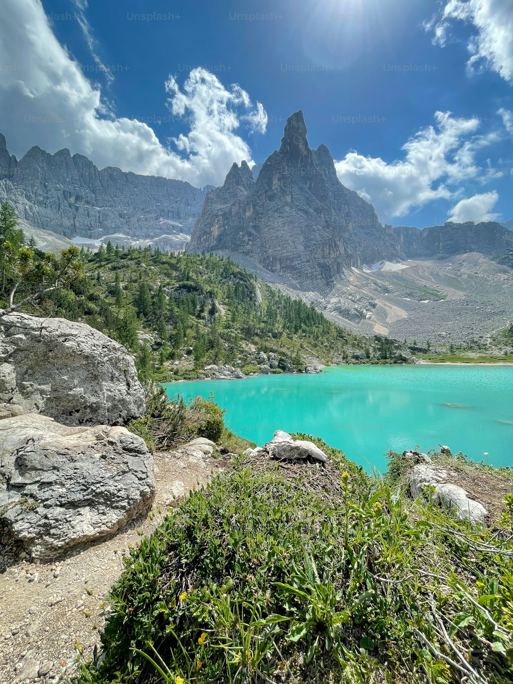 a blue lake surrounded by mountains under a blue sky