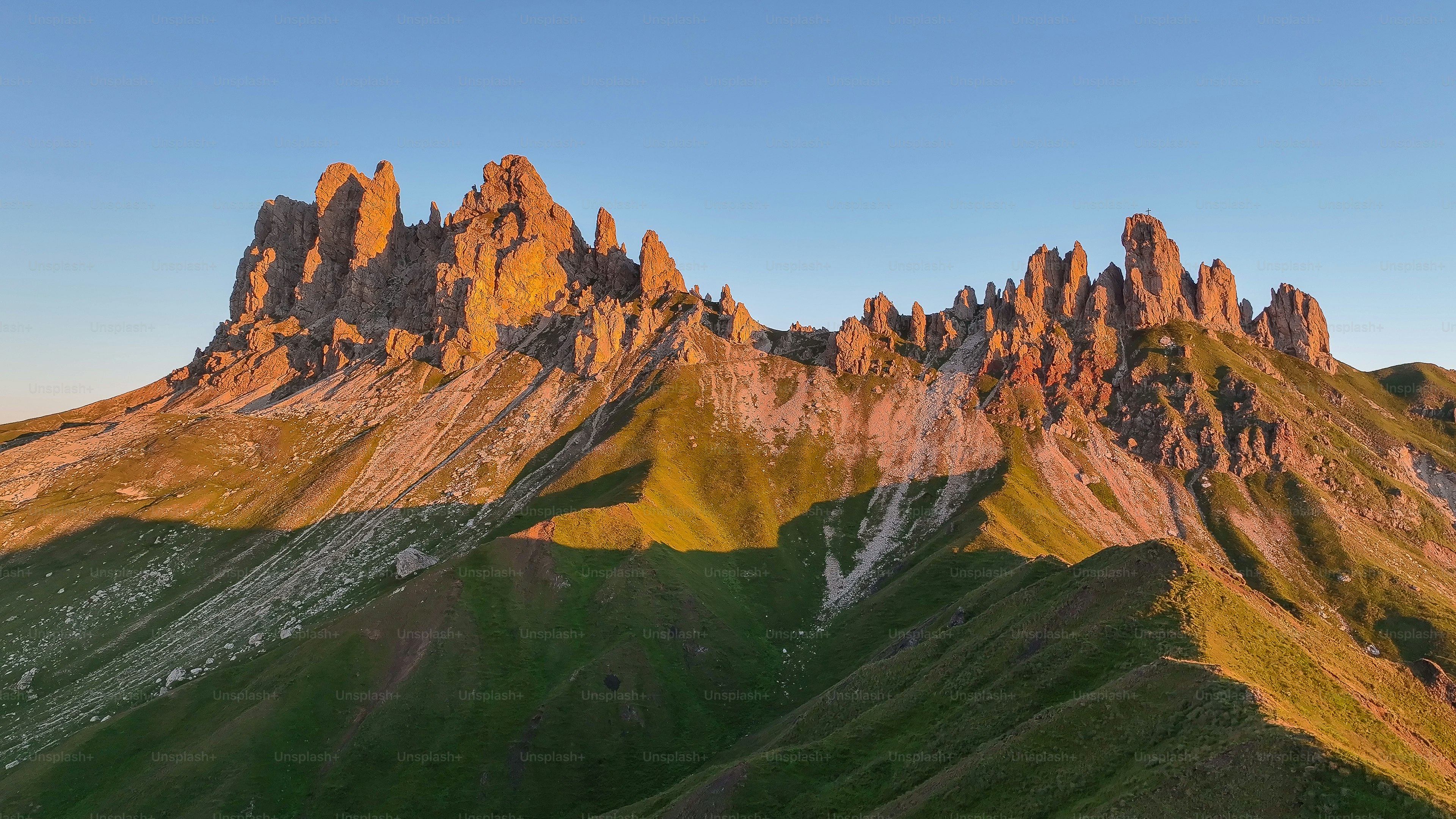 Un groupe de montagnes avec un ciel bleu en arrière-plan