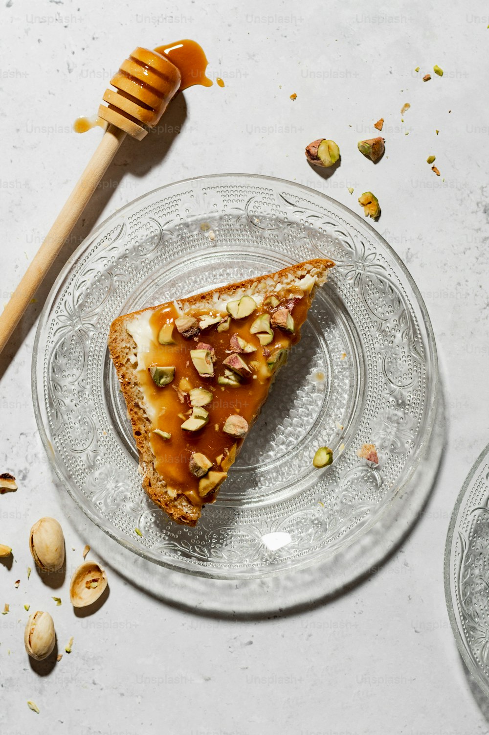 un morceau de pizza sur une assiette en verre avec un nid de miel