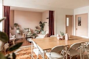uma sala de jantar com uma mesa de madeira e cadeiras brancas