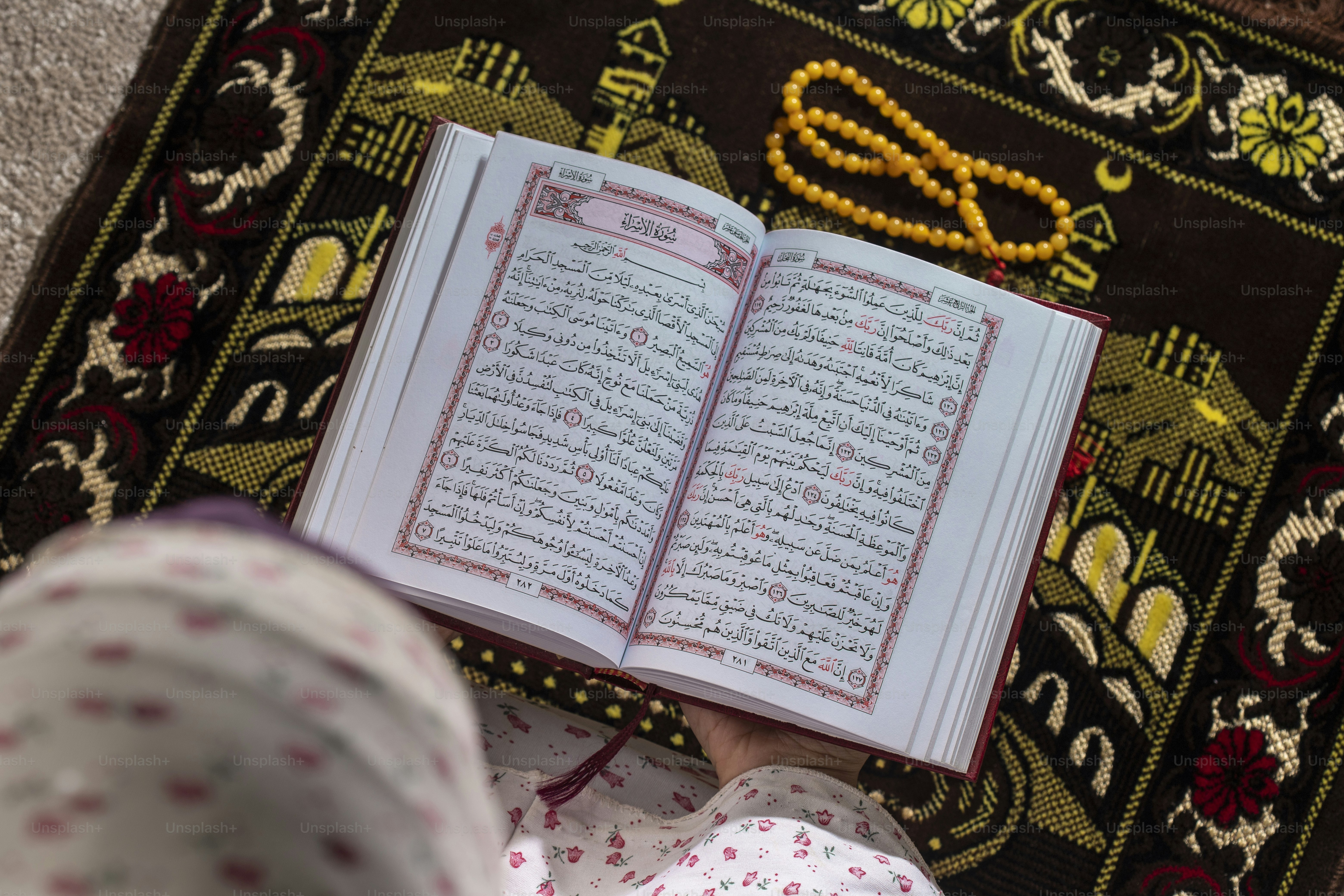 une personne lisant un livre sur un tapis