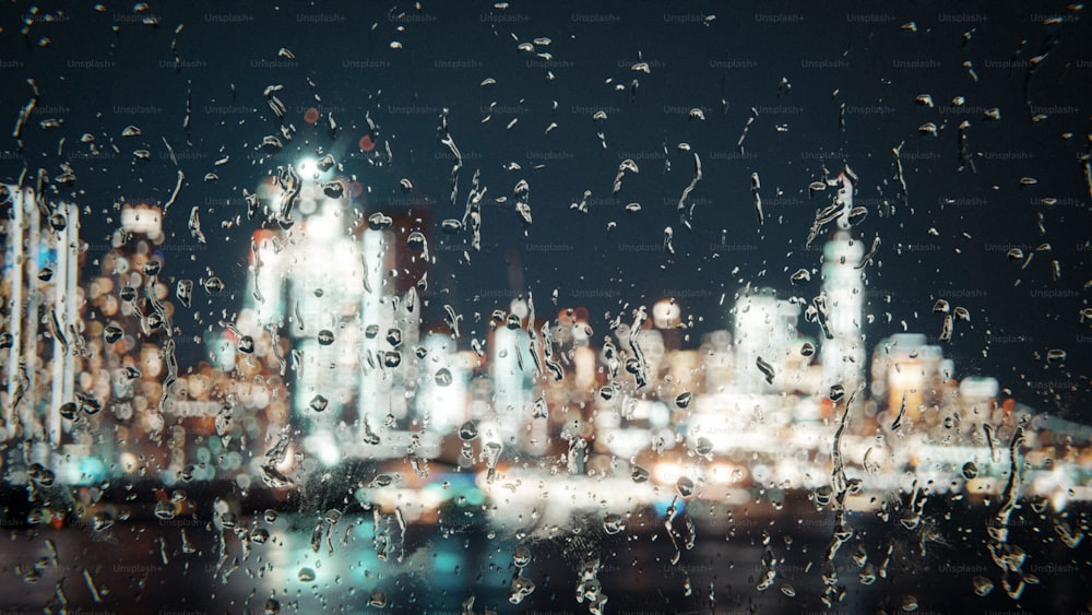 a view of a city at night through a rain covered window