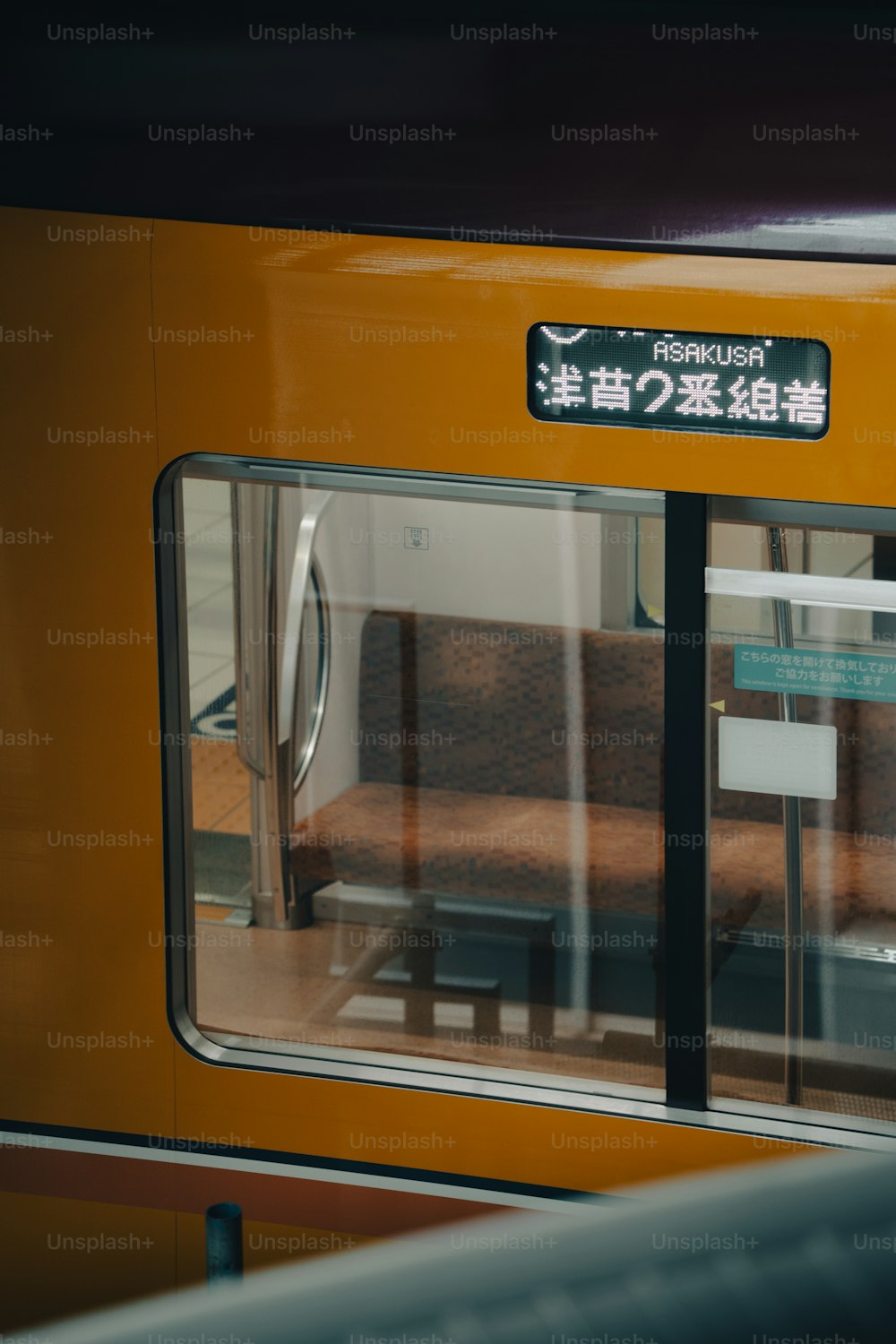 a yellow train with a sign on the side of it