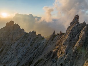 the sun is setting on a rocky mountain