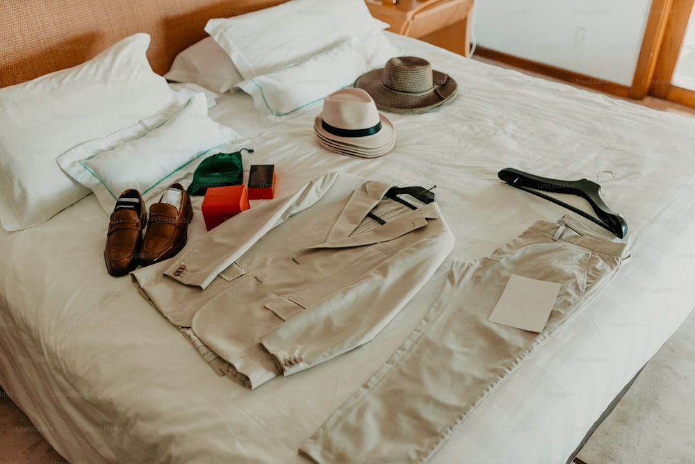 a bed topped with a white bed covered in white sheets