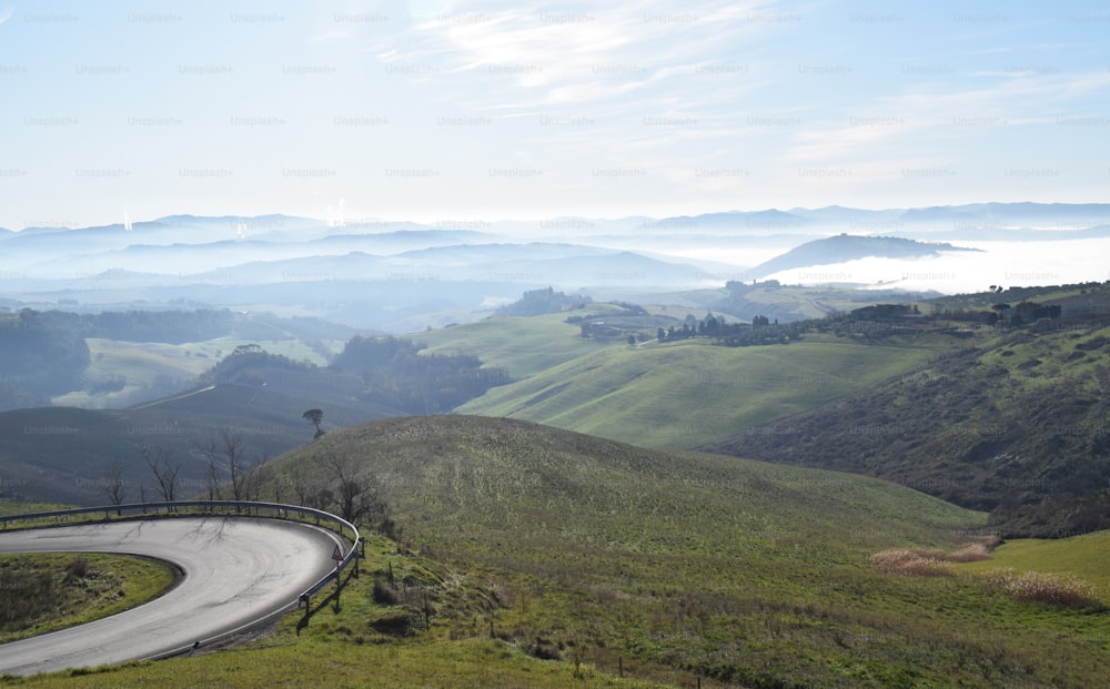 a winding road winding through a lush green hillside