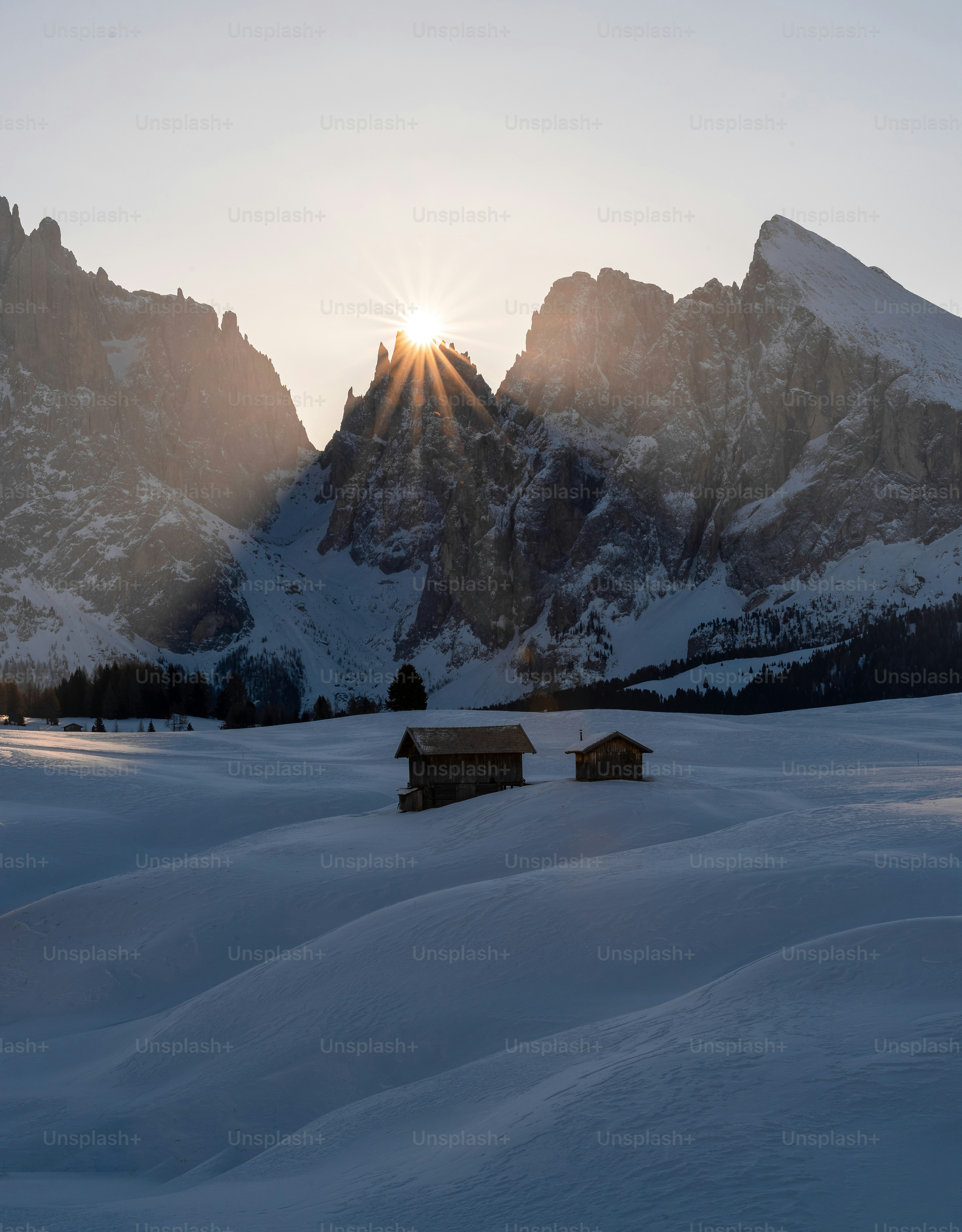 The sun is shining over a snowy mountain range photo – Snow Image on ...