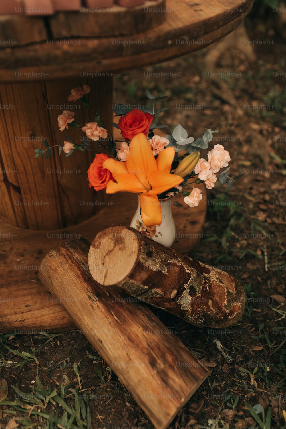 a vase filled with flowers sitting on top of a wooden stump