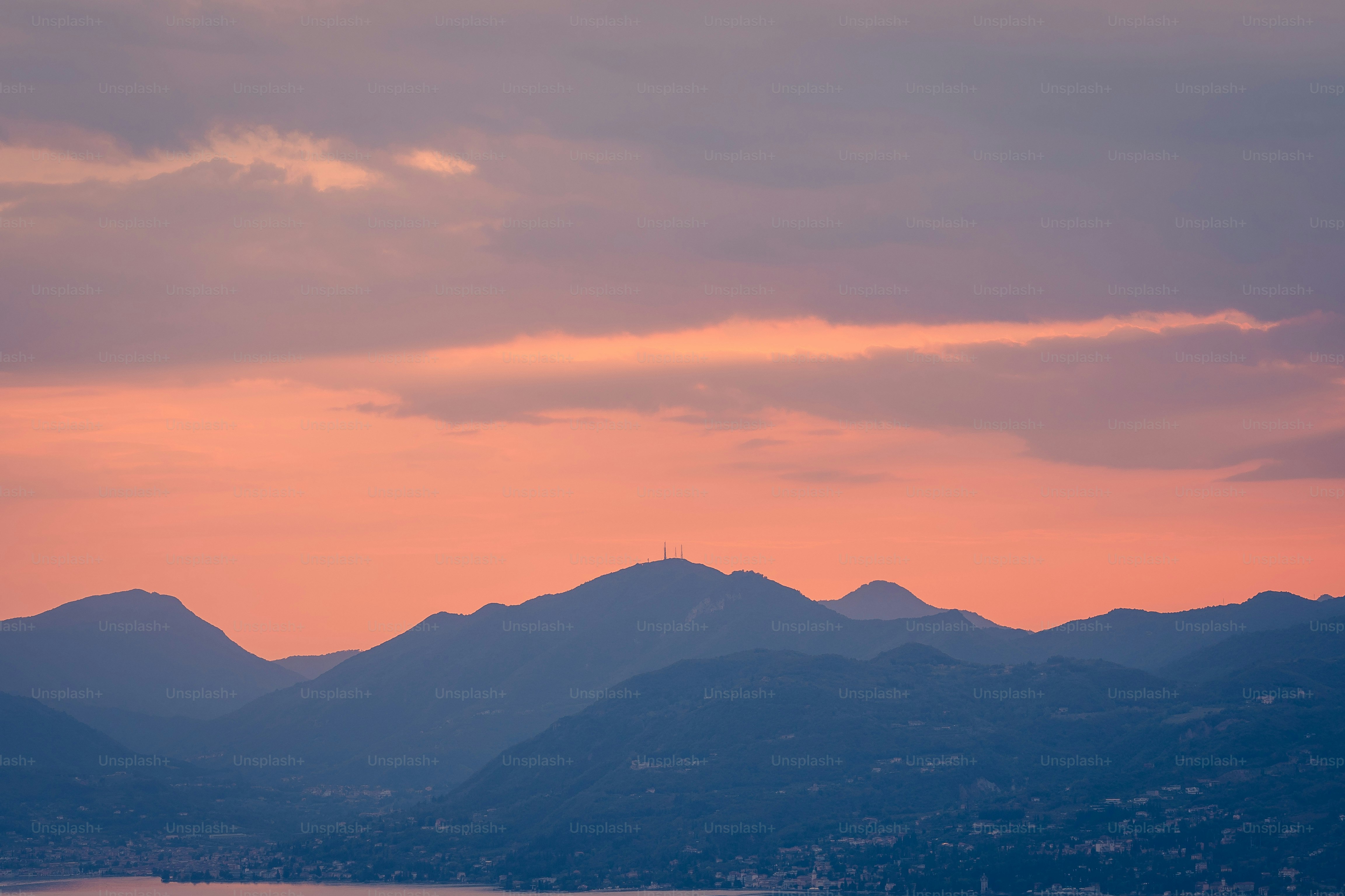 a view of mountains and a body of water at sunset