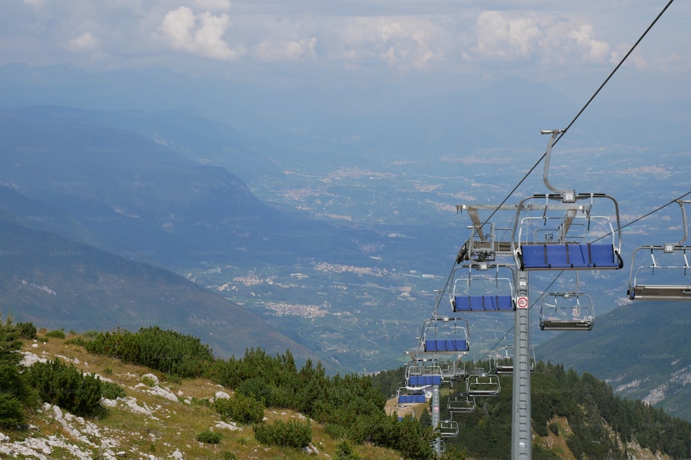 um teleférico subindo uma montanha com vista para o vale abaixo