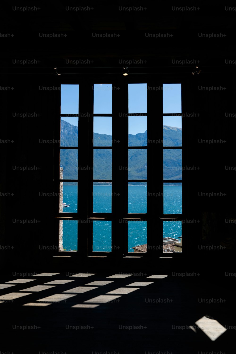 a window with a view of a lake and mountains