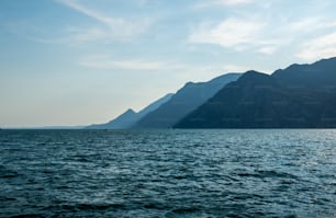 a large body of water with mountains in the background