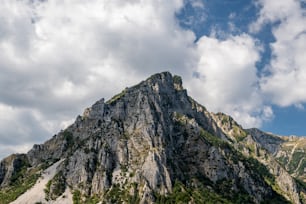 a very tall mountain with some clouds in the sky