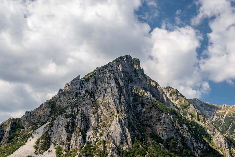 a very tall mountain with some clouds in the sky