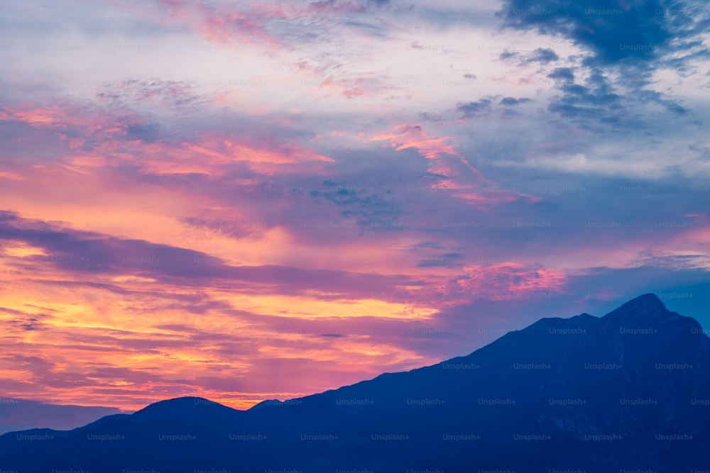 a plane flying in the sky with a mountain in the background