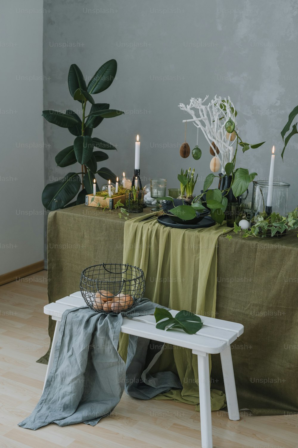 a table topped with plants and candles