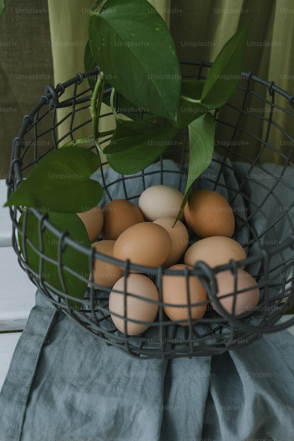 uma cesta de metal cheia de ovos em cima de uma mesa