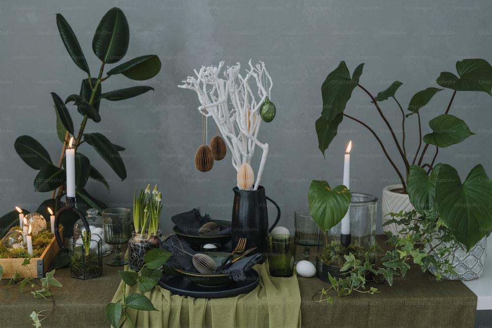 ein Tisch mit vielen Pflanzen und Kerzen