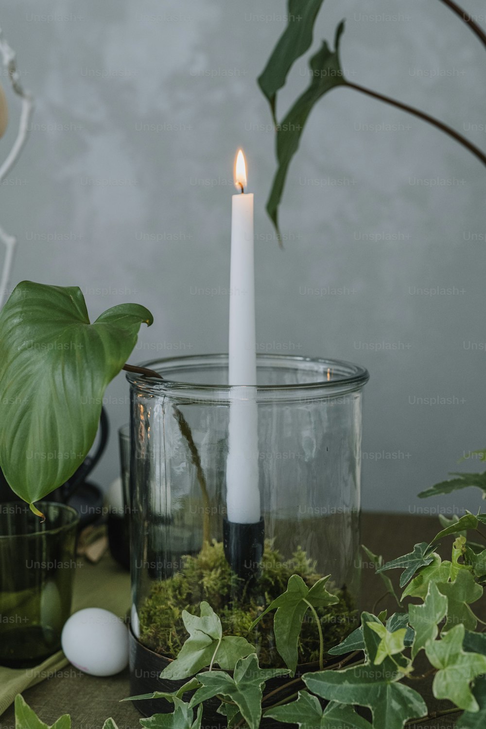a white candle is sitting in a glass