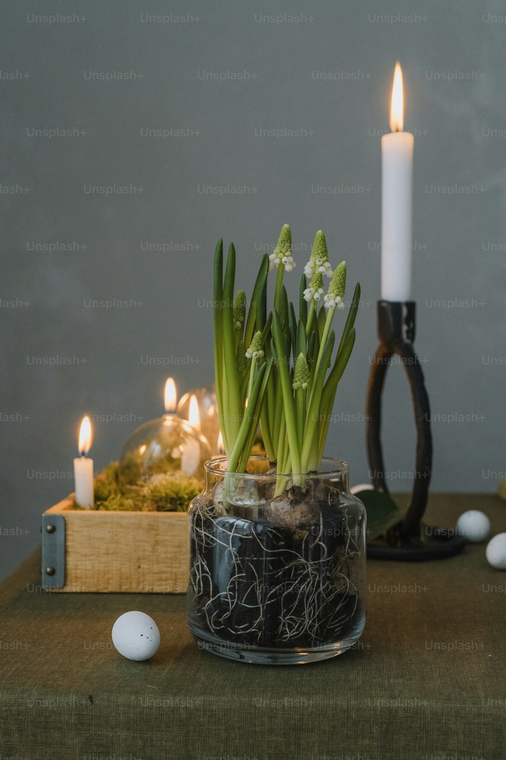 a vase with flowers and candles on a table