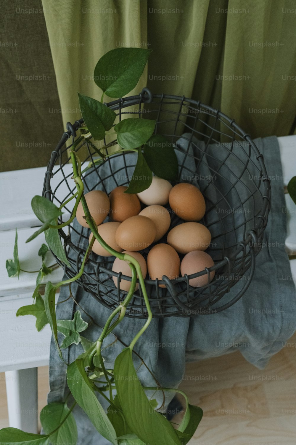 a wire basket filled with eggs sitting on top of a table
