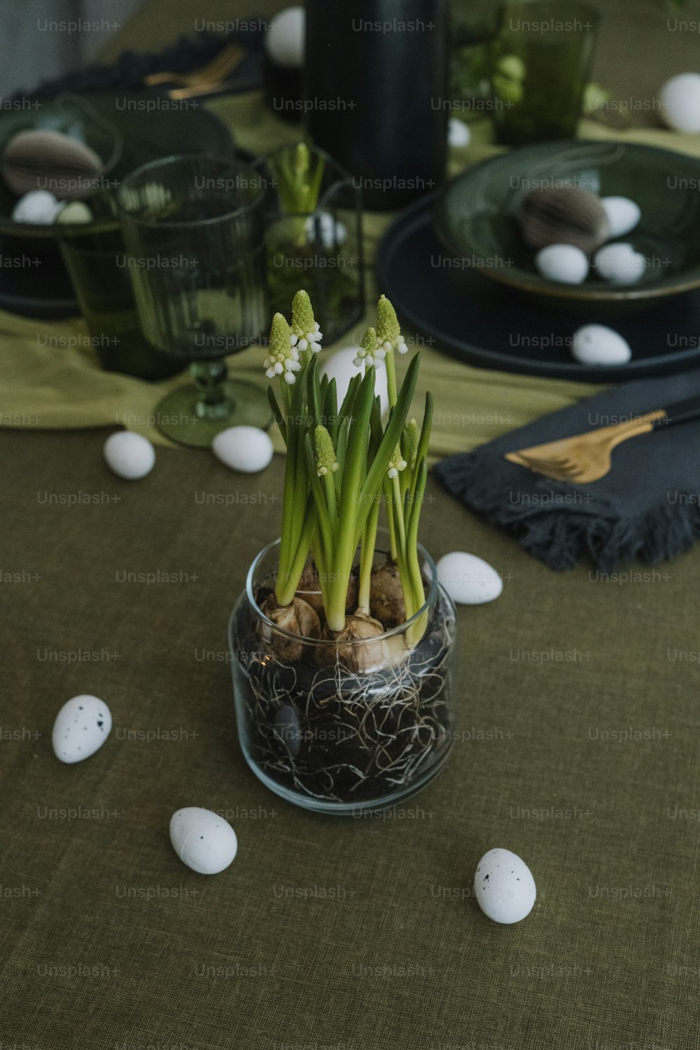 uma mesa coberta com um vaso cheio de flores e ovos