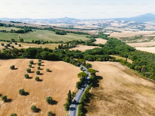 an aerial view of a country road in the middle of a field