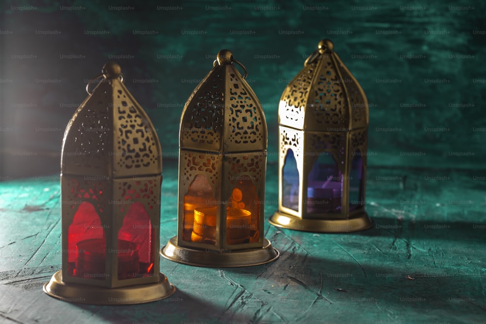 a group of three colorful lanterns sitting on top of a table