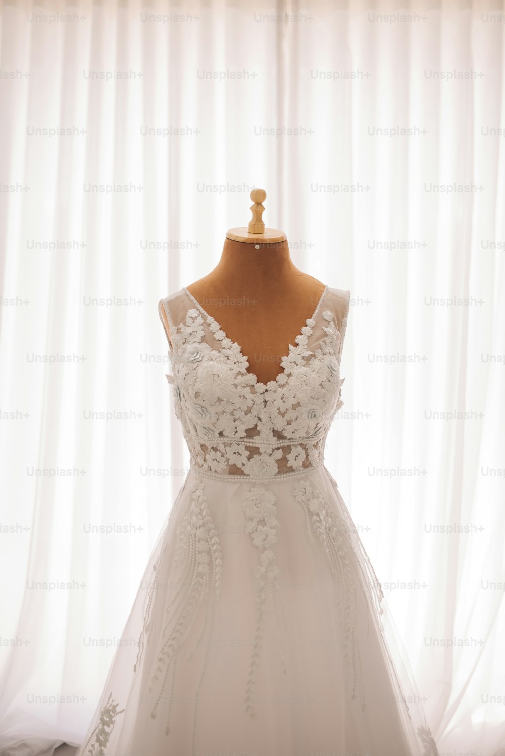 une robe sur un mannequin devant un rideau