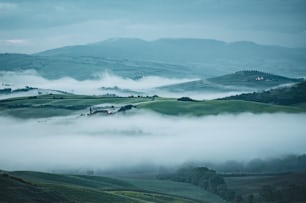a foggy valley with rolling hills in the distance