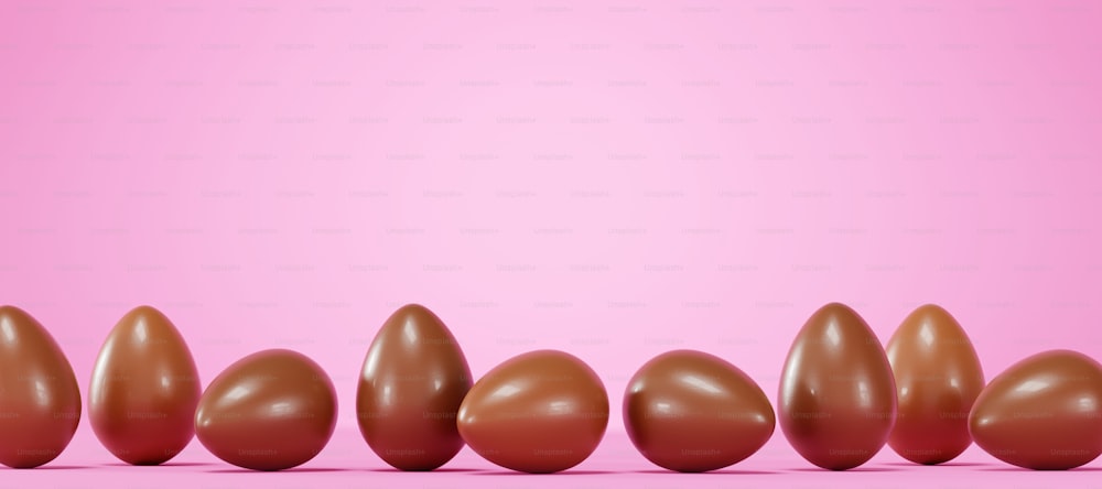 a row of chocolate eggs on a pink background