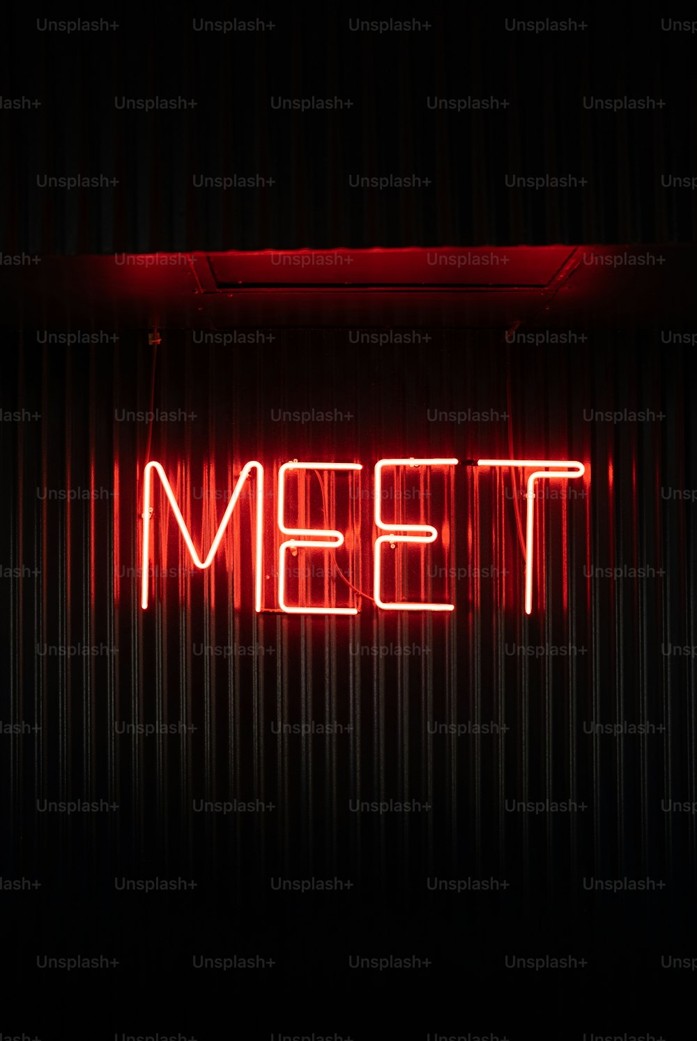 a neon sign that says meet on it