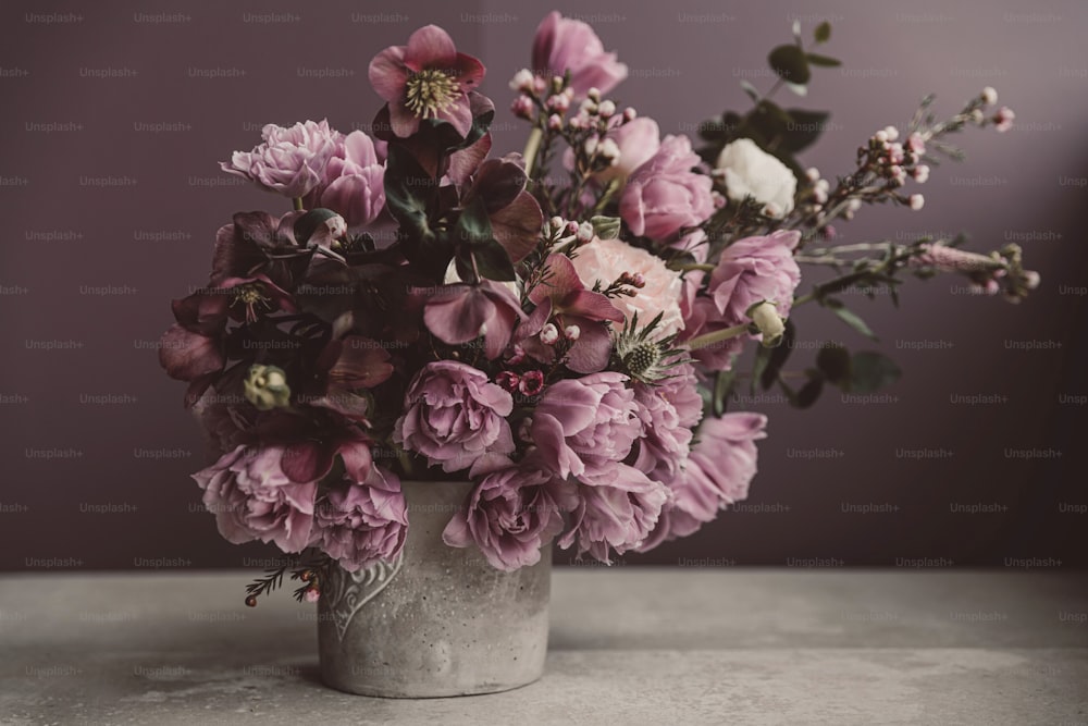 a vase filled with lots of purple flowers