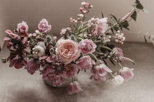 eine Vase gefüllt mit vielen rosa und weißen Blumen