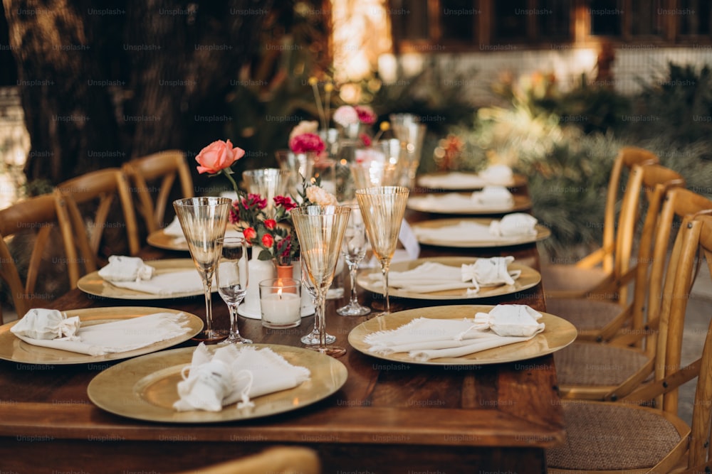 a table set for a formal dinner with wine glasses and napkins