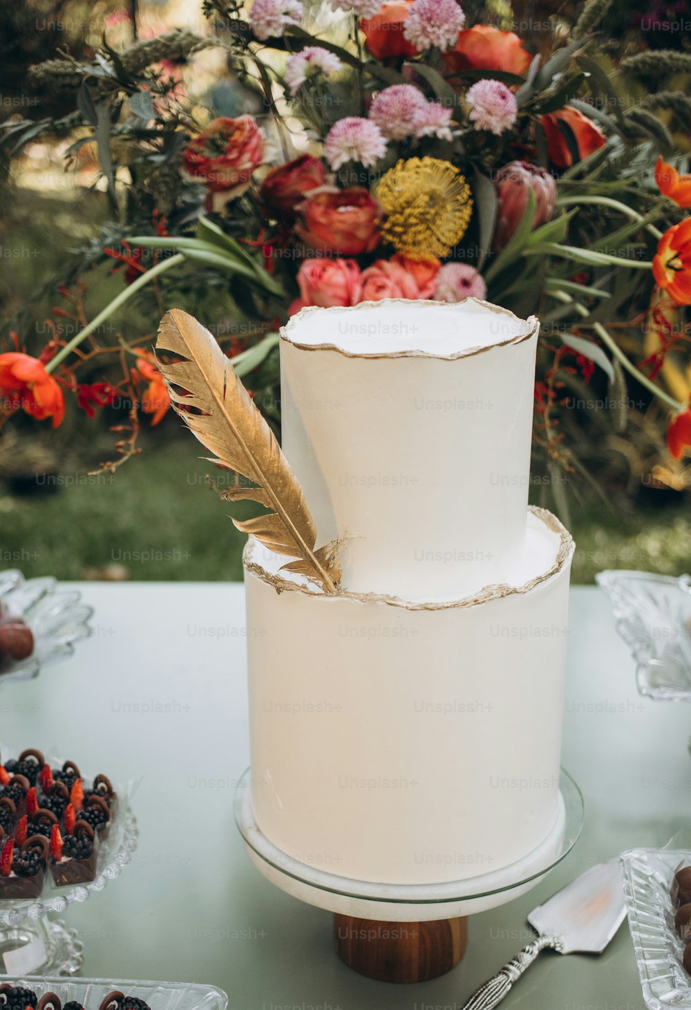 um bolo de casamento branco com uma pena em cima