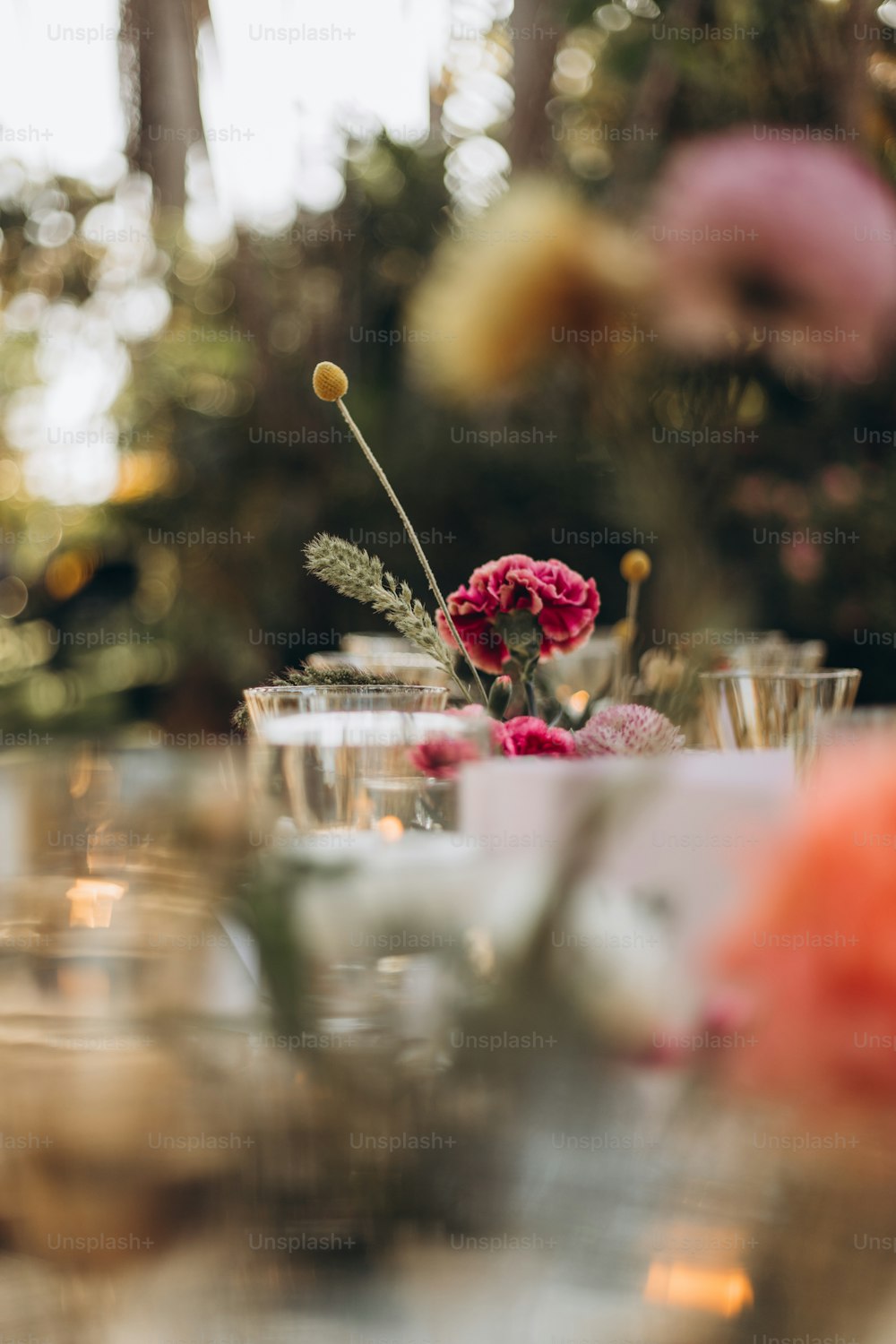 a close up of a table with glasses and flowers