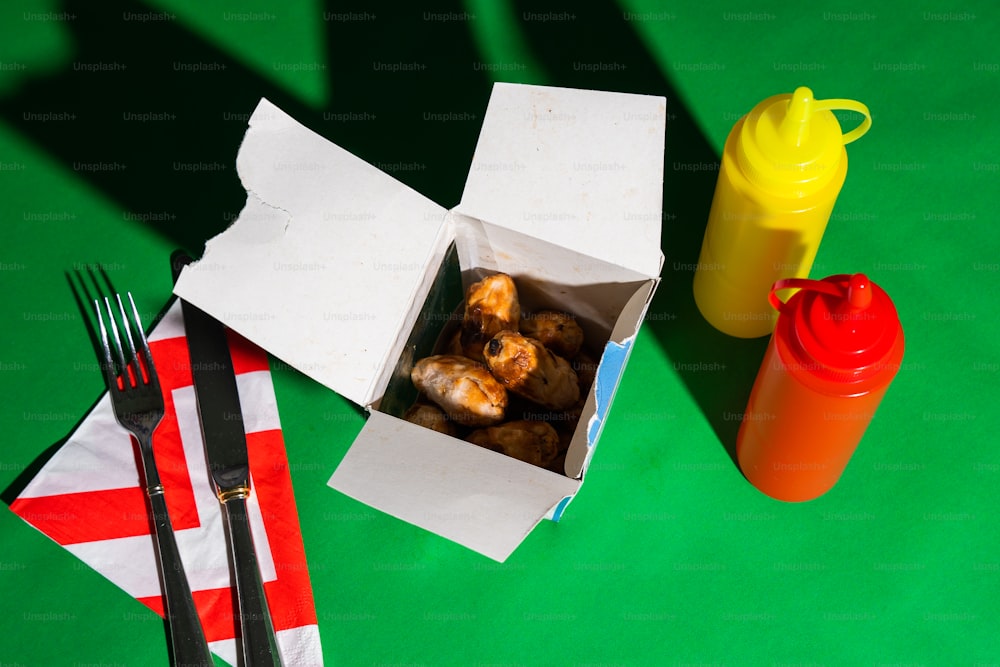 une boîte de nourriture posée sur une table à côté d’une fourchette et d’un