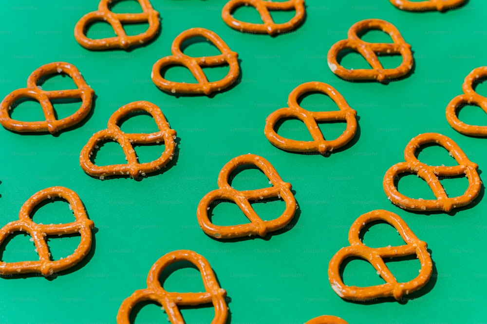 a green table topped with lots of pretzels