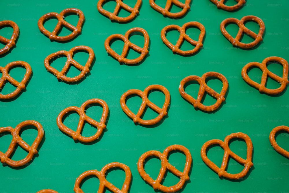a green table topped with lots of pretzels