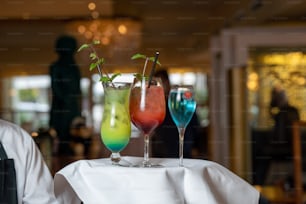 drei Gläser verschiedenfarbige Getränke auf einem Tisch