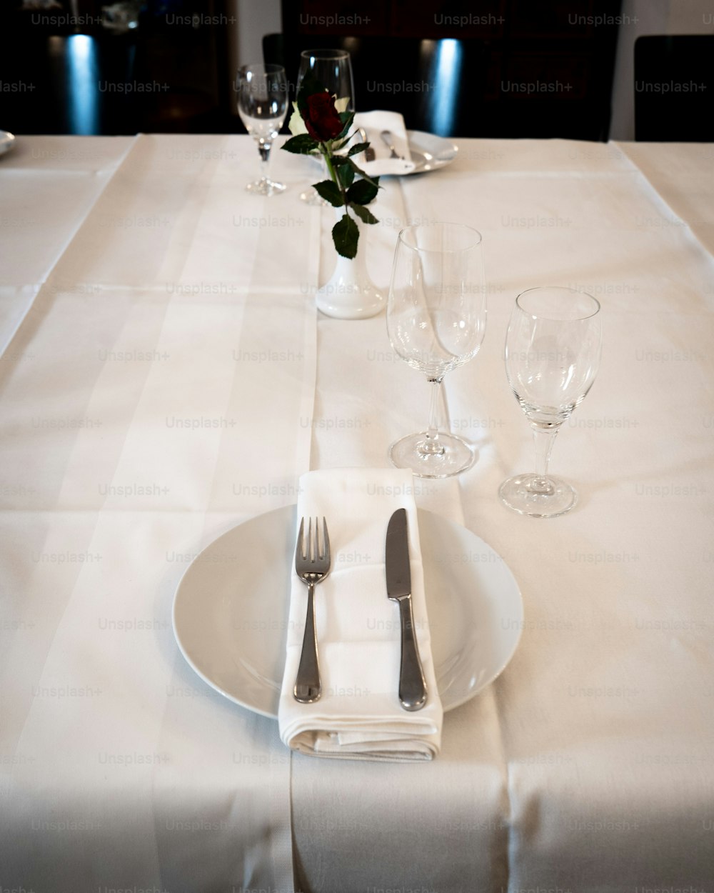 a table with a white table cloth and silverware
