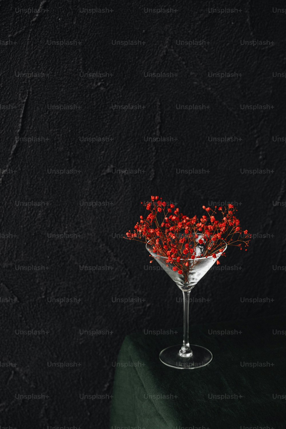 a martini glass with red berries in it