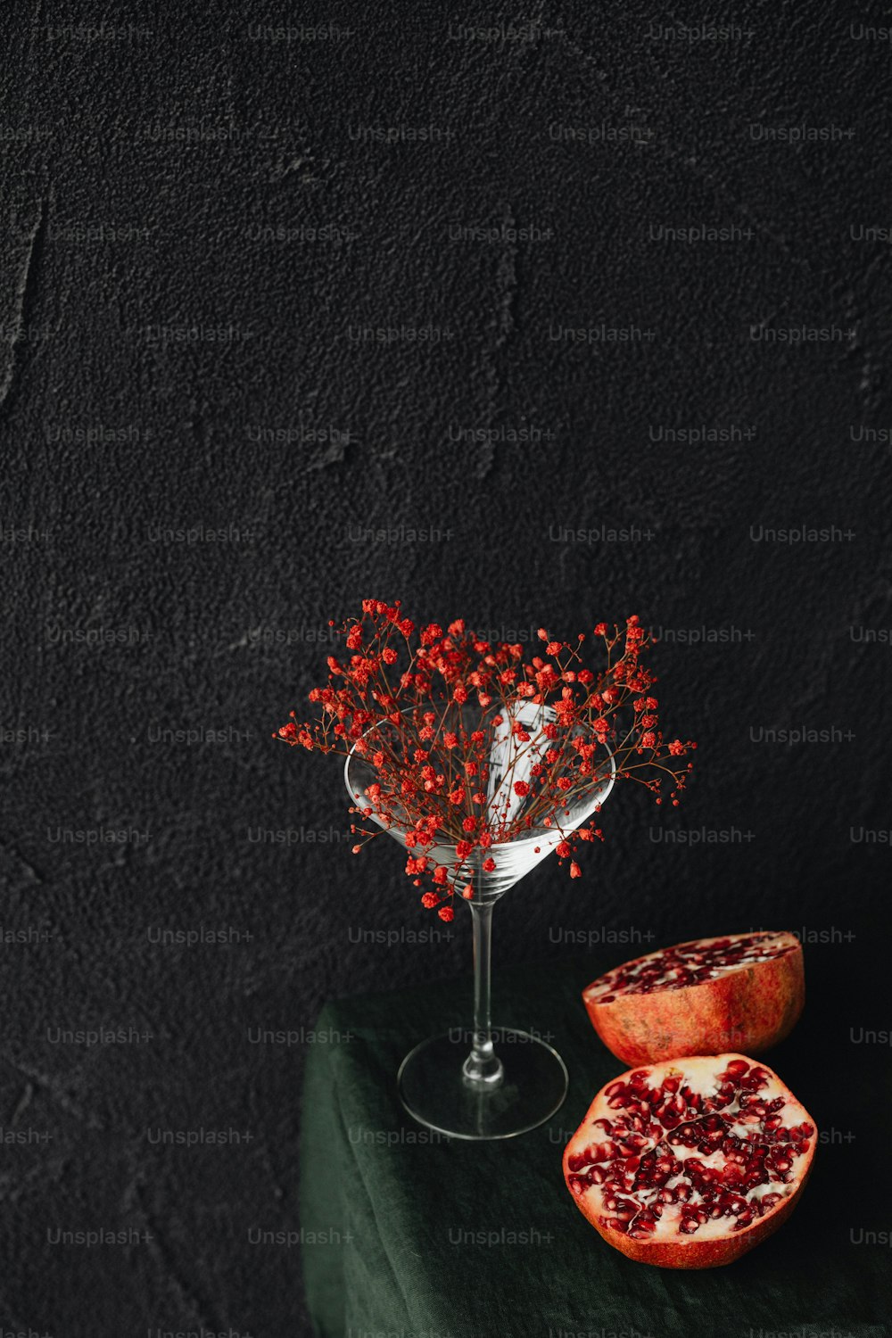 a pomegranate and a glass of wine on a table