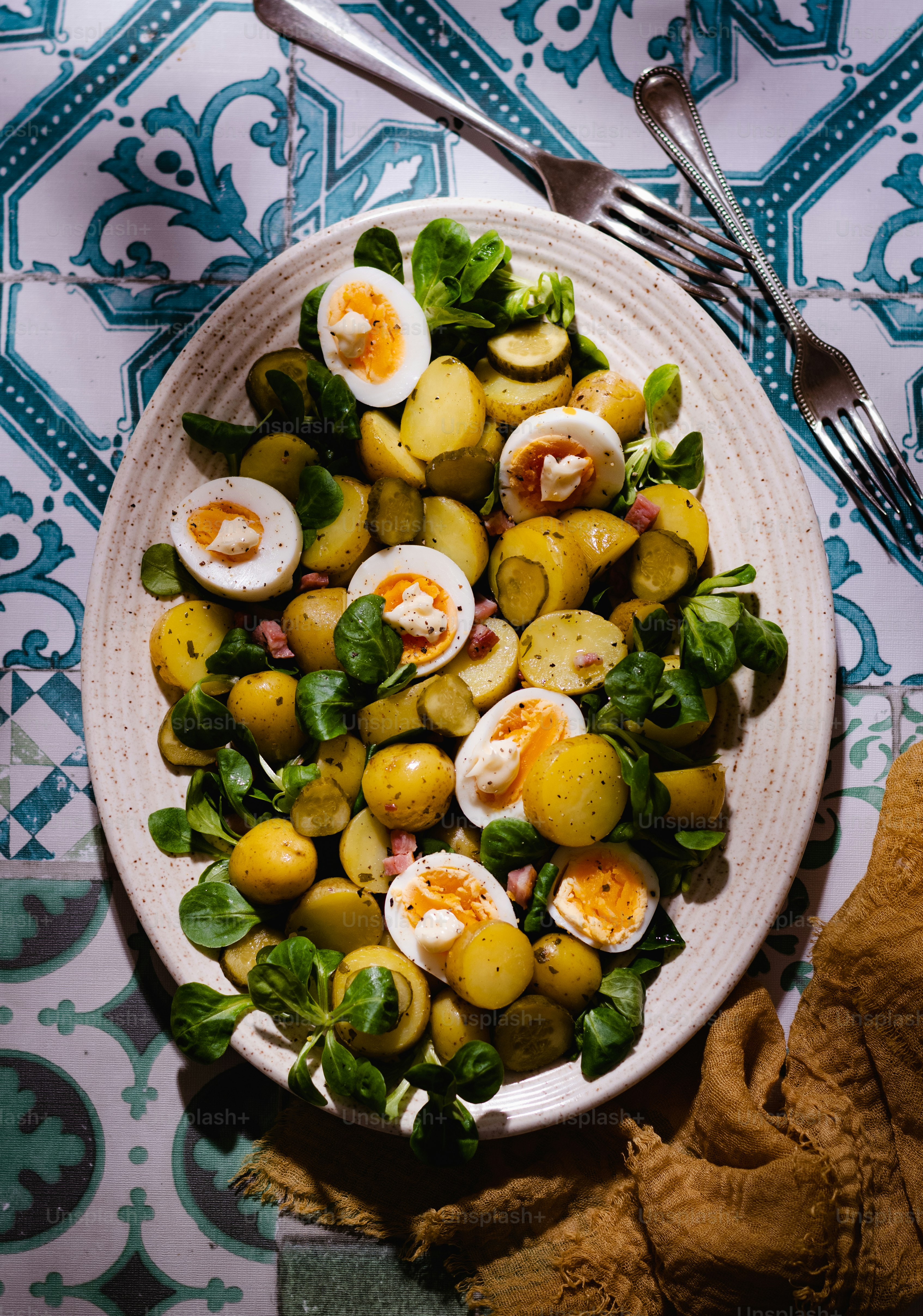 a white plate topped with a salad next to a fork