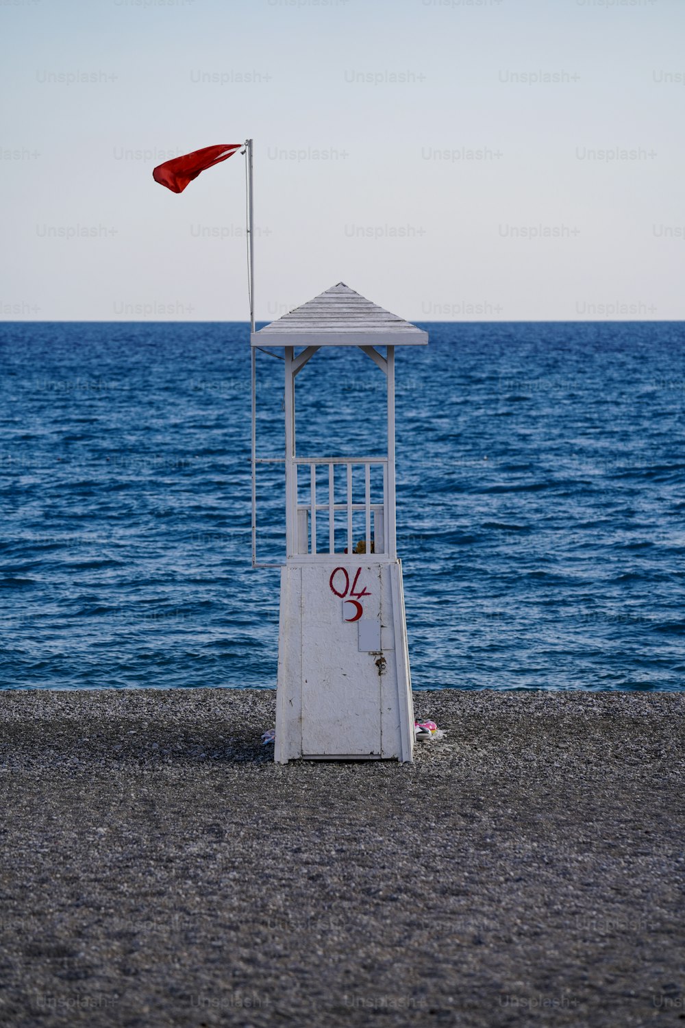 a lifeguard tower sitting on the beach next to the ocean