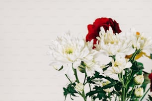 a vase filled with white and red flowers