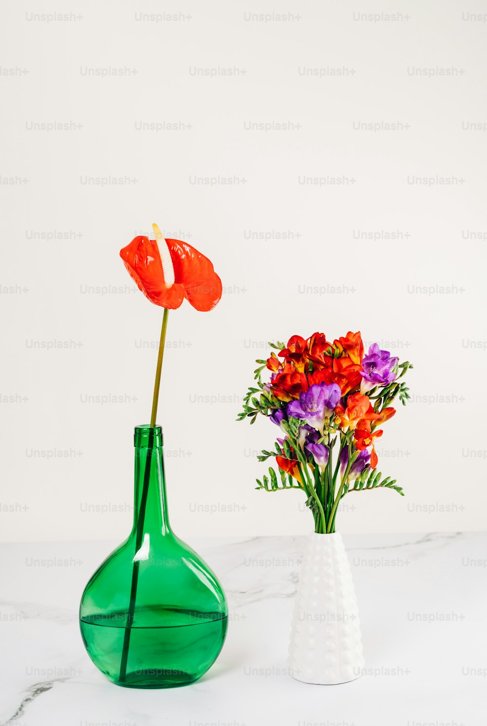 two vases with flowers in them on a table