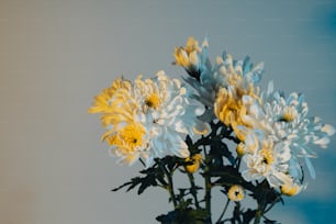 a vase filled with white and yellow flowers