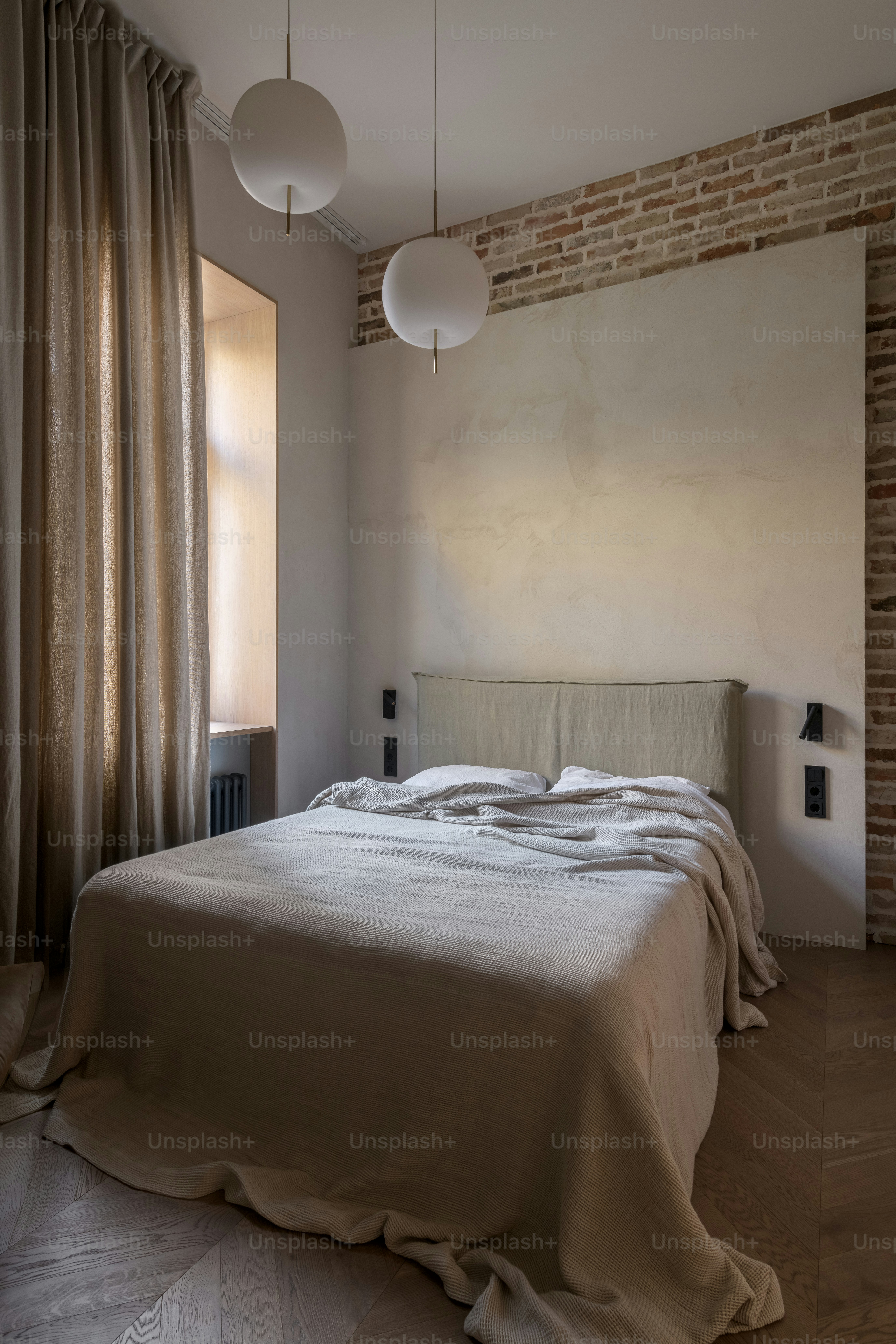 a bedroom with a bed and a brick wall